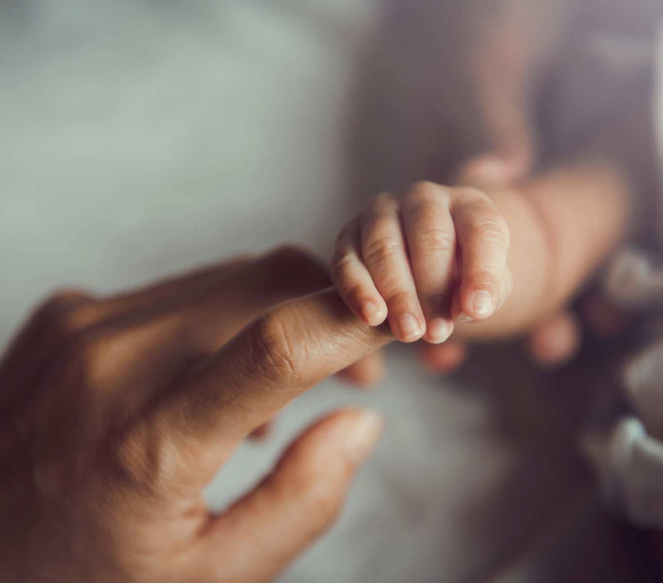 baby holding mom finger