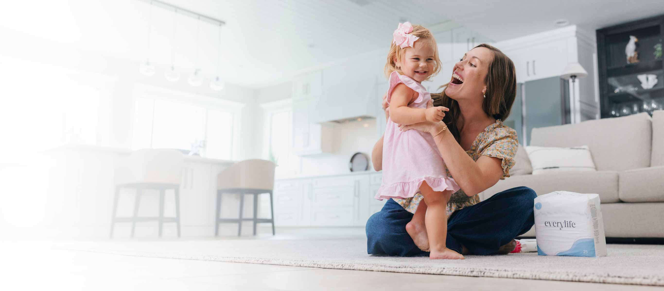 mother with daughter sitting on living room floor